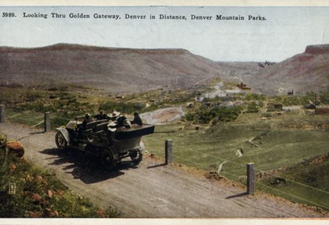 People in a car on Lookout Mountain Road look across Golden at Denver in the distance. White border era (1915-1930).