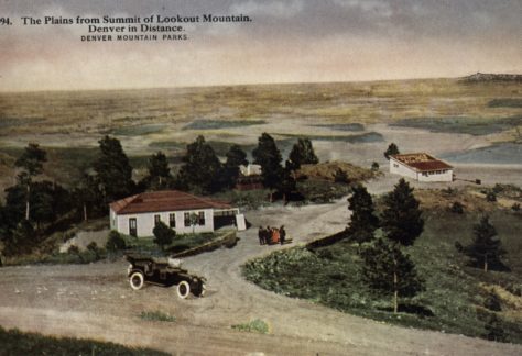 An "unsurpassed view of the plains to the east" from Lookout Mountain, Colorado with a car, building, and road in the foreground. Circa 1907 - 1914.