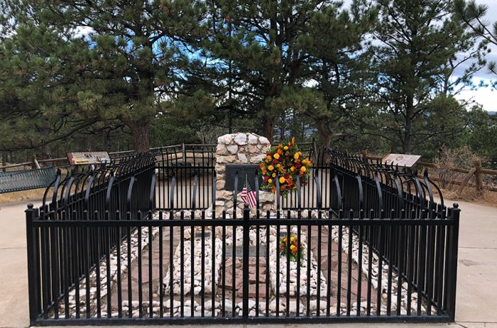 Buffalo Bills Grave at the Buffalo Bill Museum surrounded by a wrought iron fence with evergreen trees around the area.