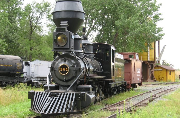 Black historic train 191 on tracks with green trees around at the Colorado Railroad Museum in Colorado.